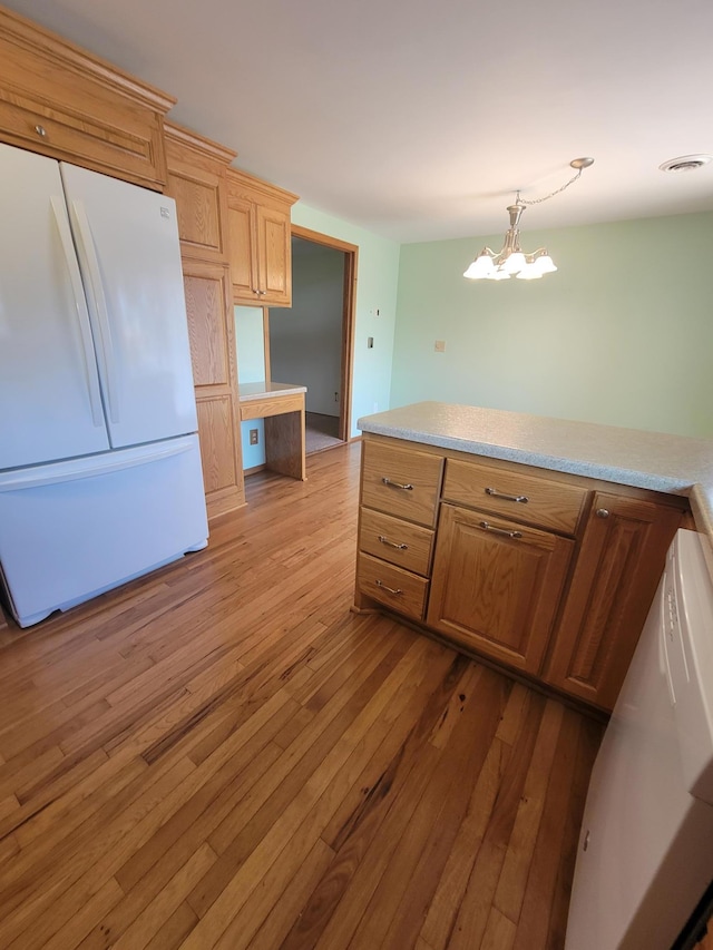 619 3rd St NW, Forest Lake, MN 55025 - kitchen featuring freestanding refrigerator, light wood-style flooring, light countertops, built in study area, and a chandelier