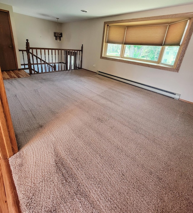 619 3rd St NW, Forest Lake, MN 55025 - carpeted spare room featuring baseboard heating and a chandelier