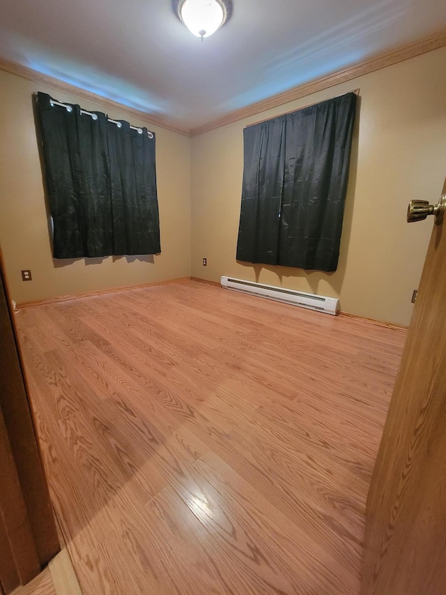 619 3rd St NW, Forest Lake, MN 55025 - spare room featuring a baseboard radiator, ornamental molding, and wood finished floors