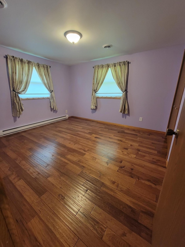 619 3rd St NW, Forest Lake, MN 55025 - spare room with a baseboard heating unit and wood-type flooring