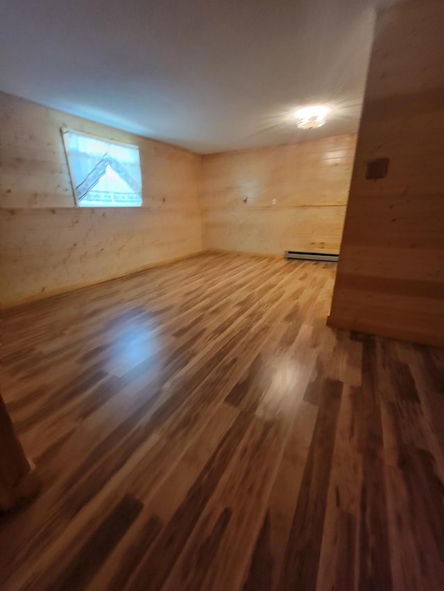 619 3rd St NW, Forest Lake, MN 55025 - empty room featuring wood finished floors, wood walls, and a baseboard heating unit