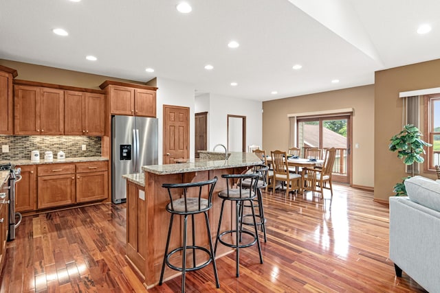 12605 314th St, Lindstrom, MN 55045 - kitchen with stainless steel appliances, brown cabinets, dark wood-style flooring, a breakfast bar, and recessed lighting