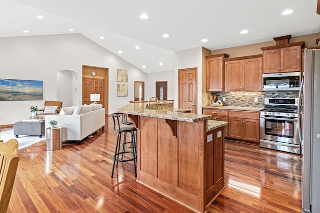 12605 314th St, Lindstrom, MN 55045 - kitchen featuring appliances with stainless steel finishes, dark wood-type flooring, arched walkways, open floor plan, and recessed lighting