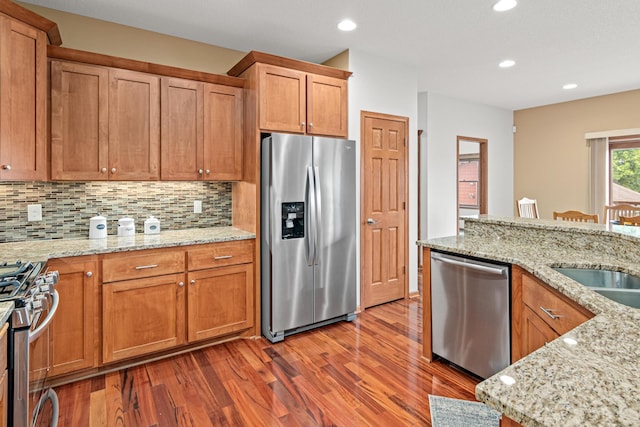 12605 314th St, Lindstrom, MN 55045 - kitchen with stainless steel appliances, wood finished floors, backsplash, recessed lighting, and light stone countertops
