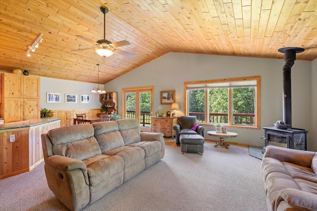 1063 Fernberg Rd, Fall Lake Twp, MN 55731 - carpeted living area with a wood stove, wood ceiling, healthy amount of natural light, lofted ceiling, and ceiling fan
