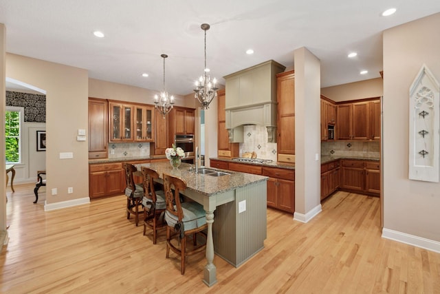 17244 Valley Rd, Eden Prairie, MN 55347 - kitchen featuring appliances with stainless steel finishes, brown cabinets, a chandelier, light wood-style flooring, and recessed lighting