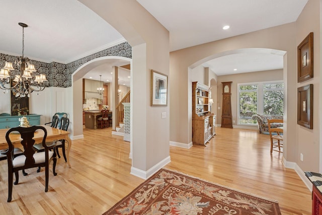 17244 Valley Rd, Eden Prairie, MN 55347 - dining area featuring a chandelier, light wood-style flooring, arched walkways, stairs, and ornamental molding