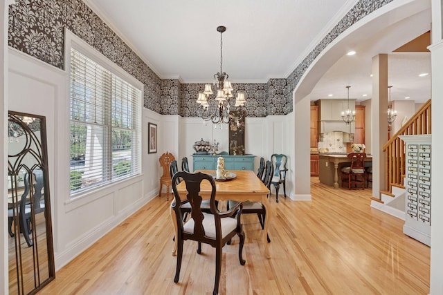 17244 Valley Rd, Eden Prairie, MN 55347 - dining room featuring a chandelier, light wood-style flooring, arched walkways, ornamental molding, and stairs