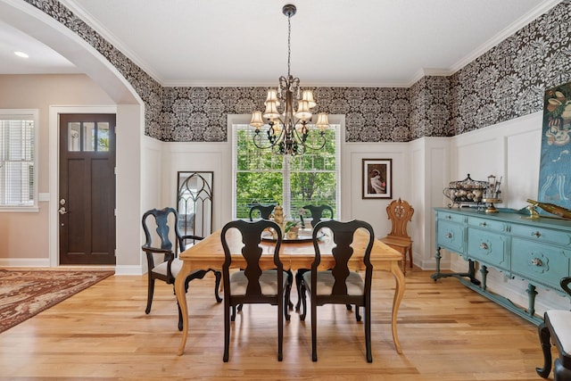 17244 Valley Rd, Eden Prairie, MN 55347 - dining room with a chandelier, arched walkways, a decorative wall, light wood-style flooring, and ornamental molding