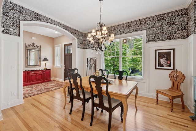 17244 Valley Rd, Eden Prairie, MN 55347 - dining room featuring arched walkways, light wood-style flooring, a chandelier, crown molding, and wallpapered walls