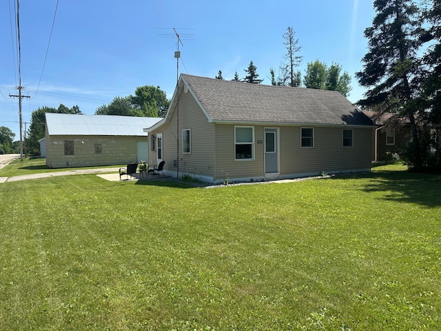 502 1st Ave SW, Baudette, MN 56623 - view of front facade with a front lawn, a patio, and a shingled roof