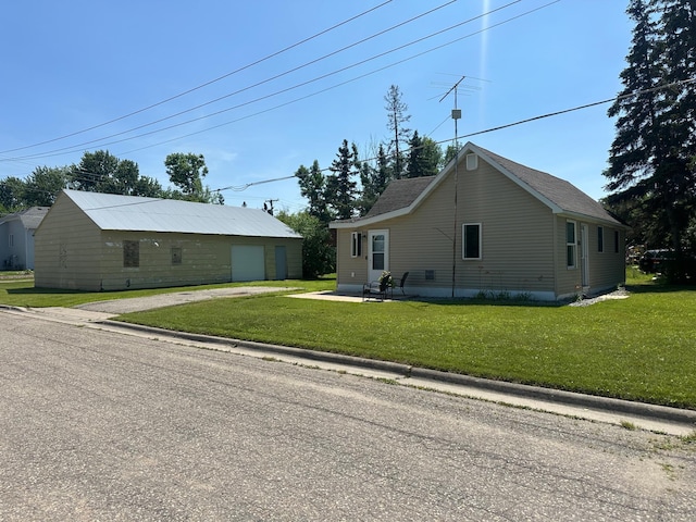 502 1st Ave SW, Baudette, MN 56623 - view of front facade featuring a front lawn, a garage, an outdoor structure, and driveway