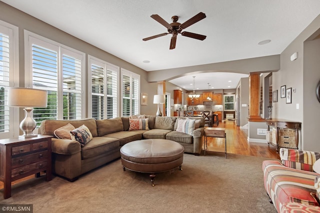 3631 Woodcrest Cir, Eagan, MN 55123 - living room featuring arched walkways, ceiling fan, light colored carpet, and ornate columns
