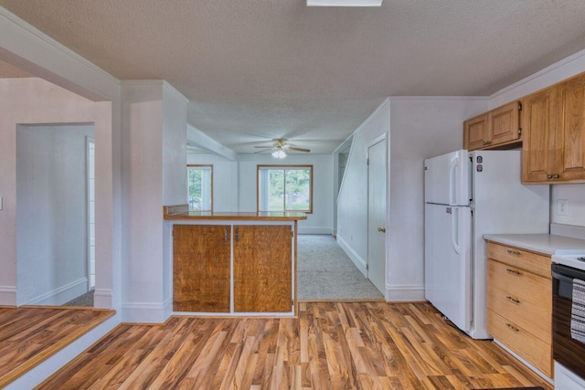 3026 5th Ave E, Hibbing, MN 55746 - kitchen featuring a textured ceiling, light wood-style flooring, light countertops, electric stove, and a ceiling fan