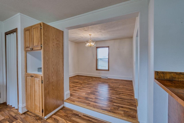 3026 5th Ave E, Hibbing, MN 55746 - kitchen featuring a textured ceiling, wood finished floors, a chandelier, and dark countertops