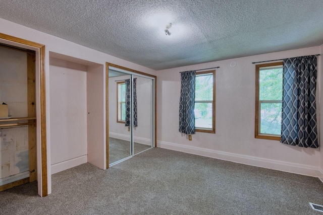 3026 5th Ave E, Hibbing, MN 55746 - unfurnished bedroom with a textured ceiling, carpet, and a closet