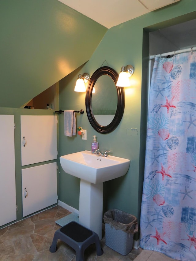 703 1st St SW, Wadena, MN 56482 - full bathroom featuring lofted ceiling, a shower with curtain, and stone finish flooring