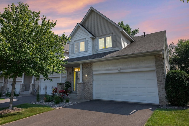 10931 185th Cir NW, Elk River, MN 55330 - traditional-style house featuring driveway, a shingled roof, and brick siding