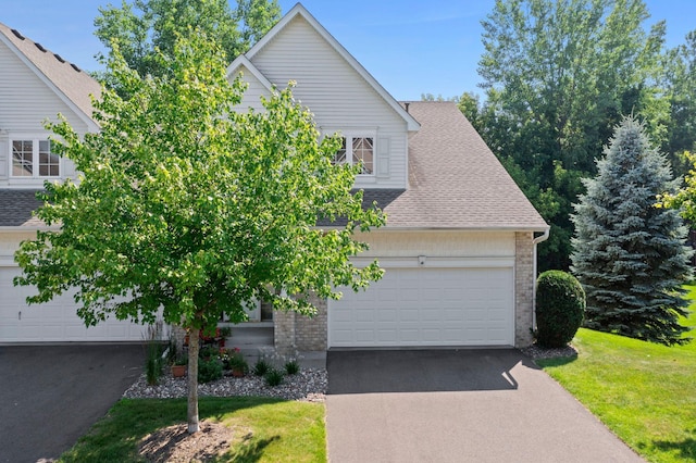 10931 185th Cir NW, Elk River, MN 55330 - view of front of property with asphalt driveway, a shingled roof, brick siding, an attached garage, and a front lawn