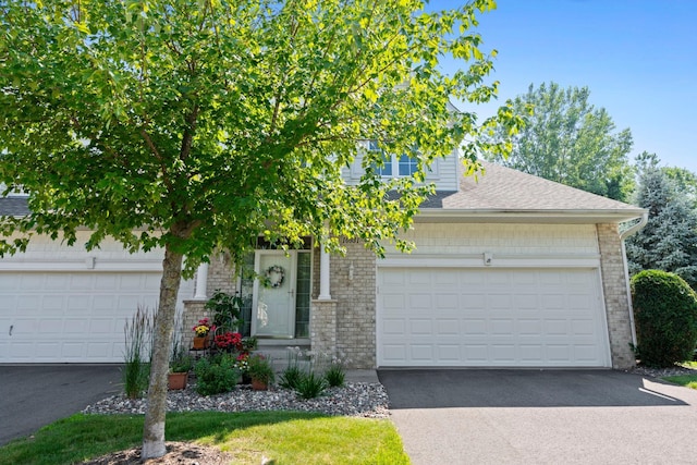 10931 185th Cir NW, Elk River, MN 55330 - obstructed view of property with brick siding, roof with shingles, asphalt driveway, and a garage