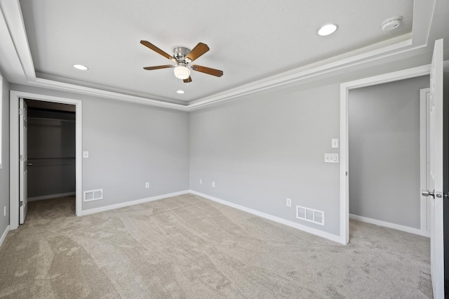 509 2nd St S, Montrose, MN 55363 - unfurnished bedroom with a tray ceiling, a spacious closet, carpet, recessed lighting, and a ceiling fan