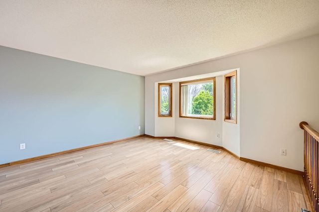 2208 84th Ave N, Brooklyn Park, MN 55444 - empty room with light wood-style floors and a textured ceiling