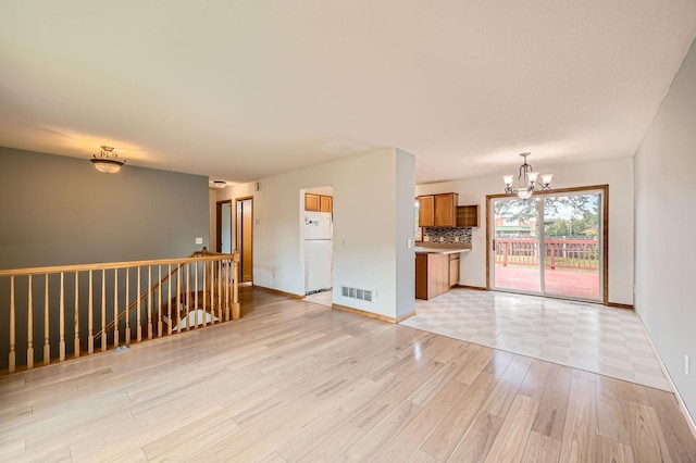 2208 84th Ave N, Brooklyn Park, MN 55444 - unfurnished living room with a chandelier and light wood-type flooring
