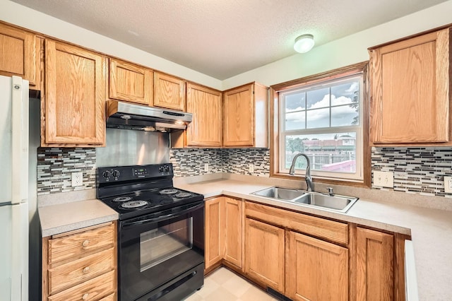 2208 84th Ave N, Brooklyn Park, MN 55444 - kitchen featuring black electric range oven, under cabinet range hood, light countertops, freestanding refrigerator, and decorative backsplash