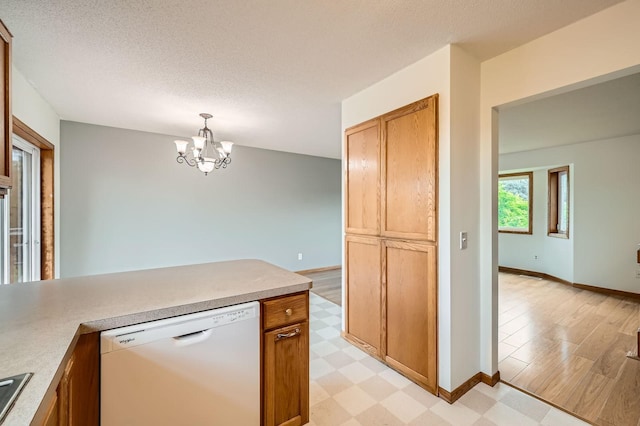 2208 84th Ave N, Brooklyn Park, MN 55444 - kitchen with white dishwasher, light floors, a chandelier, light countertops, and a textured ceiling