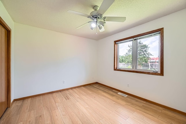 2208 84th Ave N, Brooklyn Park, MN 55444 - unfurnished room featuring light wood-style floors, ceiling fan, and a textured ceiling