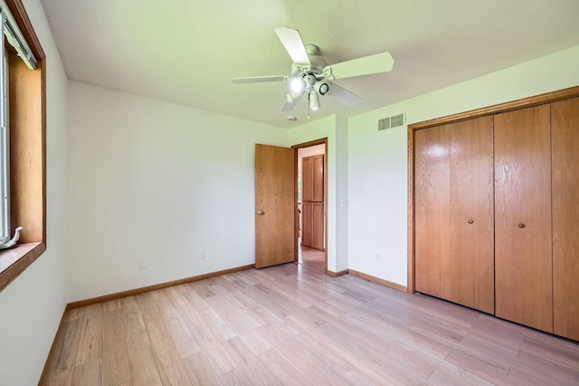 2208 84th Ave N, Brooklyn Park, MN 55444 - unfurnished bedroom with light wood-style floors, a closet, and a ceiling fan