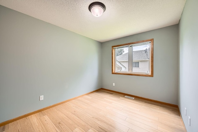 2208 84th Ave N, Brooklyn Park, MN 55444 - unfurnished room with a textured ceiling and wood finished floors