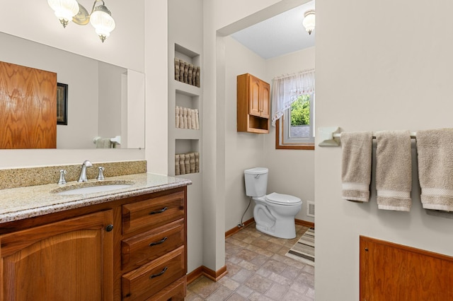 5833 Perry Ave N, Crystal, MN 55429 - bathroom featuring vanity, built in shelves, stone finish flooring, and a chandelier