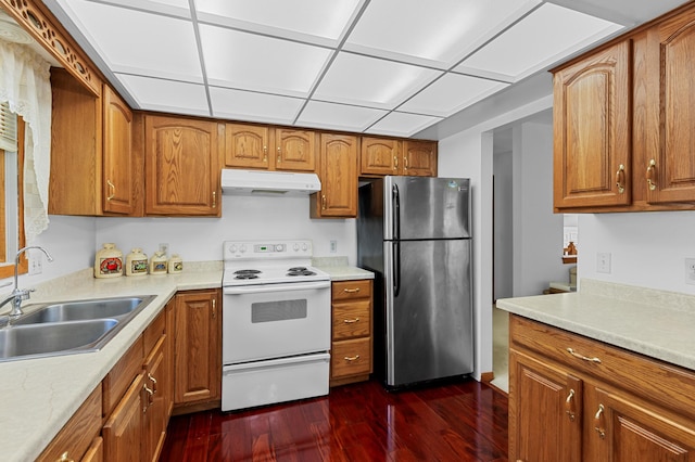 5833 Perry Ave N, Crystal, MN 55429 - kitchen with freestanding refrigerator, white electric stove, under cabinet range hood, dark wood finished floors, and brown cabinetry