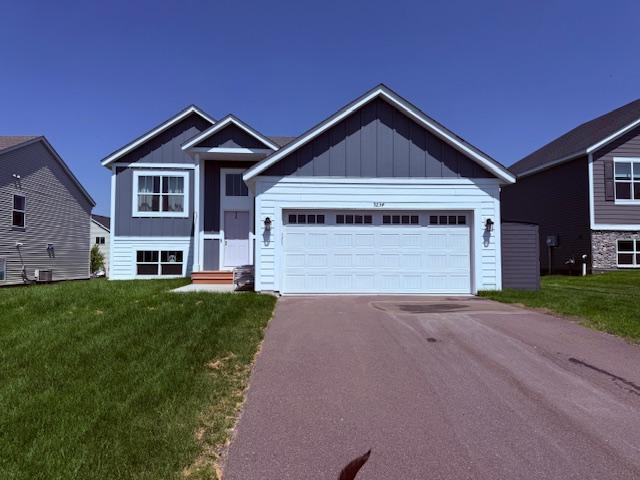 9234 25th St NE, Saint Michael, MN 55376 - view of front of home with asphalt driveway, a front yard, and board and batten siding