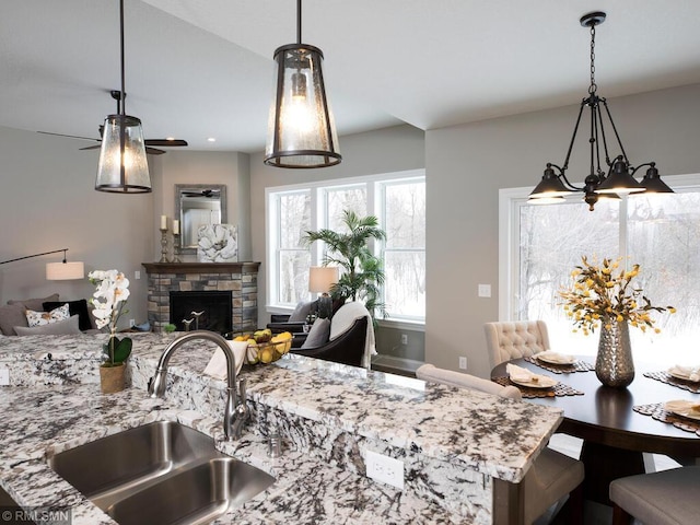 0000 Central Dr NE, Cambridge, MN 55008 - kitchen featuring open floor plan, light stone counters, a stone fireplace, and decorative light fixtures