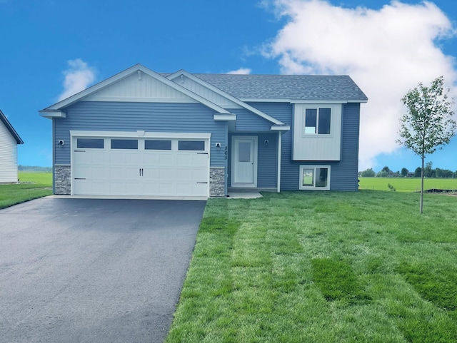 935 2 1/2 Ave, Rice, MN 56367 - view of front of property with driveway, a front yard, a garage, stone siding, and a shingled roof