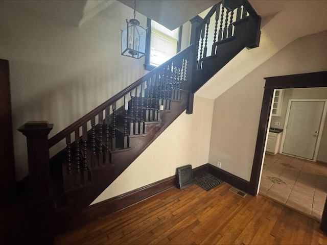 1051 Mclean Ave, Saint Paul, MN 55106 - stairs with hardwood / wood-style flooring and vaulted ceiling