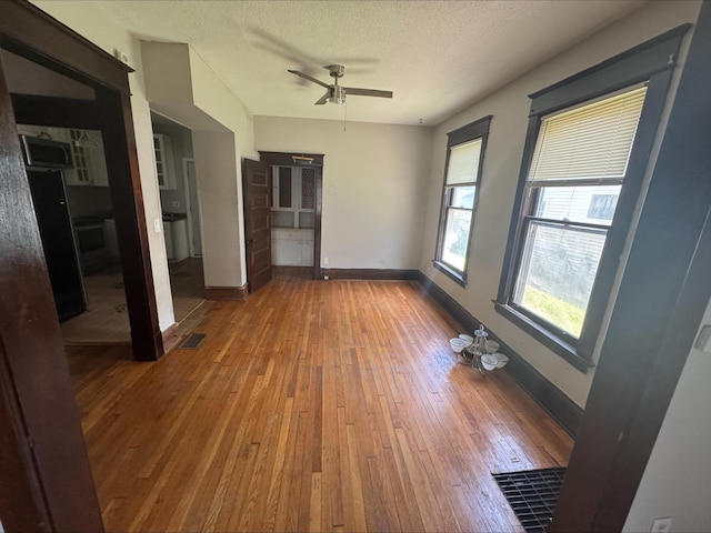 1051 Mclean Ave, Saint Paul, MN 55106 - unfurnished room with hardwood / wood-style floors, ceiling fan, and a textured ceiling