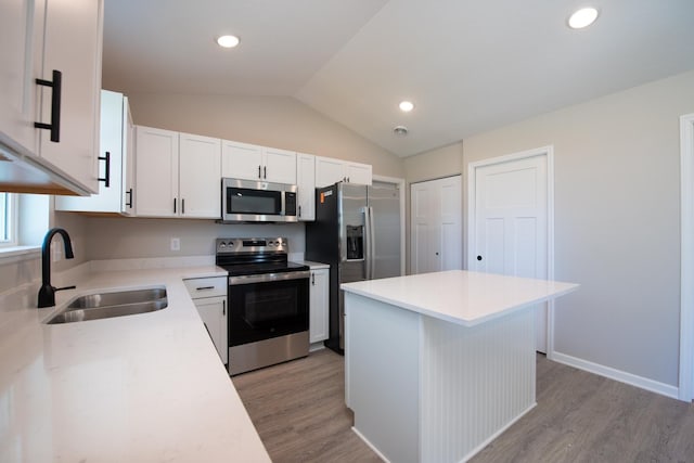3101 Scotch Ln, Mankato, MN 56001 - kitchen featuring appliances with stainless steel finishes, vaulted ceiling, light wood-style floors, white cabinetry, and light countertops