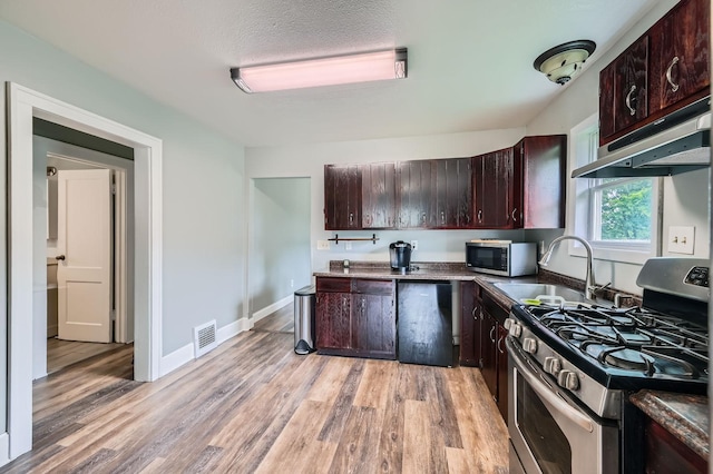 1076 Wilson Ave, Saint Paul, MN 55106 - kitchen featuring stainless steel appliances, light wood finished floors, under cabinet range hood, dark brown cabinetry, and dark countertops