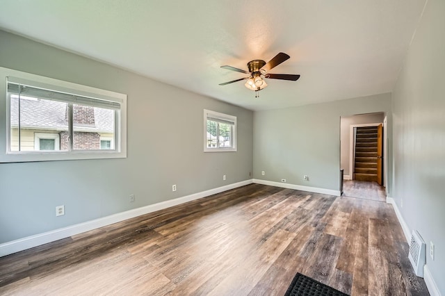 1076 Wilson Ave, Saint Paul, MN 55106 - empty room featuring ceiling fan, wood finished floors, and stairway