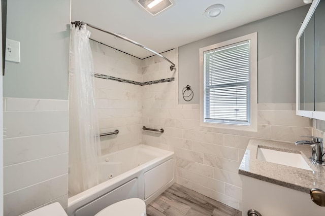 1076 Wilson Ave, Saint Paul, MN 55106 - bathroom with tile walls, shower / bath combo with shower curtain, vanity, and a wainscoted wall
