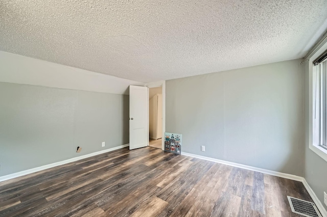 1076 Wilson Ave, Saint Paul, MN 55106 - empty room featuring dark wood-type flooring and a textured ceiling