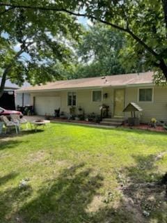 10178 Uplander St NW, Coon Rapids, MN 55433 - back of property featuring an attached garage and a yard