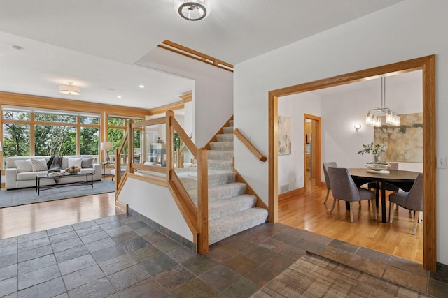 4301 Overlook Dr, Bloomington, MN 55437 - staircase featuring stone tile flooring and a chandelier