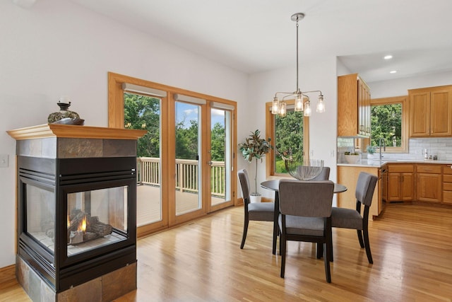 4301 Overlook Dr, Bloomington, MN 55437 - dining space featuring light wood-type flooring, a multi sided fireplace, a chandelier, and recessed lighting