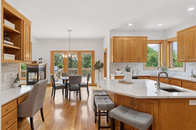 4301 Overlook Dr, Bloomington, MN 55437 - kitchen with backsplash, light wood finished floors, a kitchen breakfast bar, recessed lighting, and hanging light fixtures