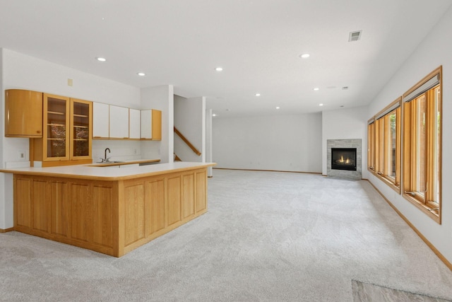 4301 Overlook Dr, Bloomington, MN 55437 - kitchen with light colored carpet, recessed lighting, light countertops, glass insert cabinets, and a fireplace