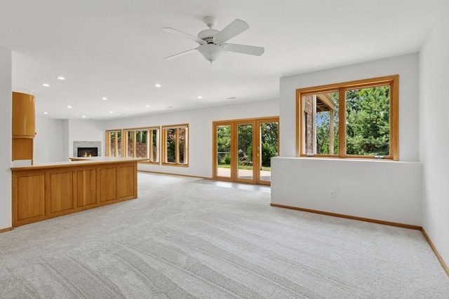 4301 Overlook Dr, Bloomington, MN 55437 - unfurnished living room featuring light carpet, a warm lit fireplace, recessed lighting, and a ceiling fan